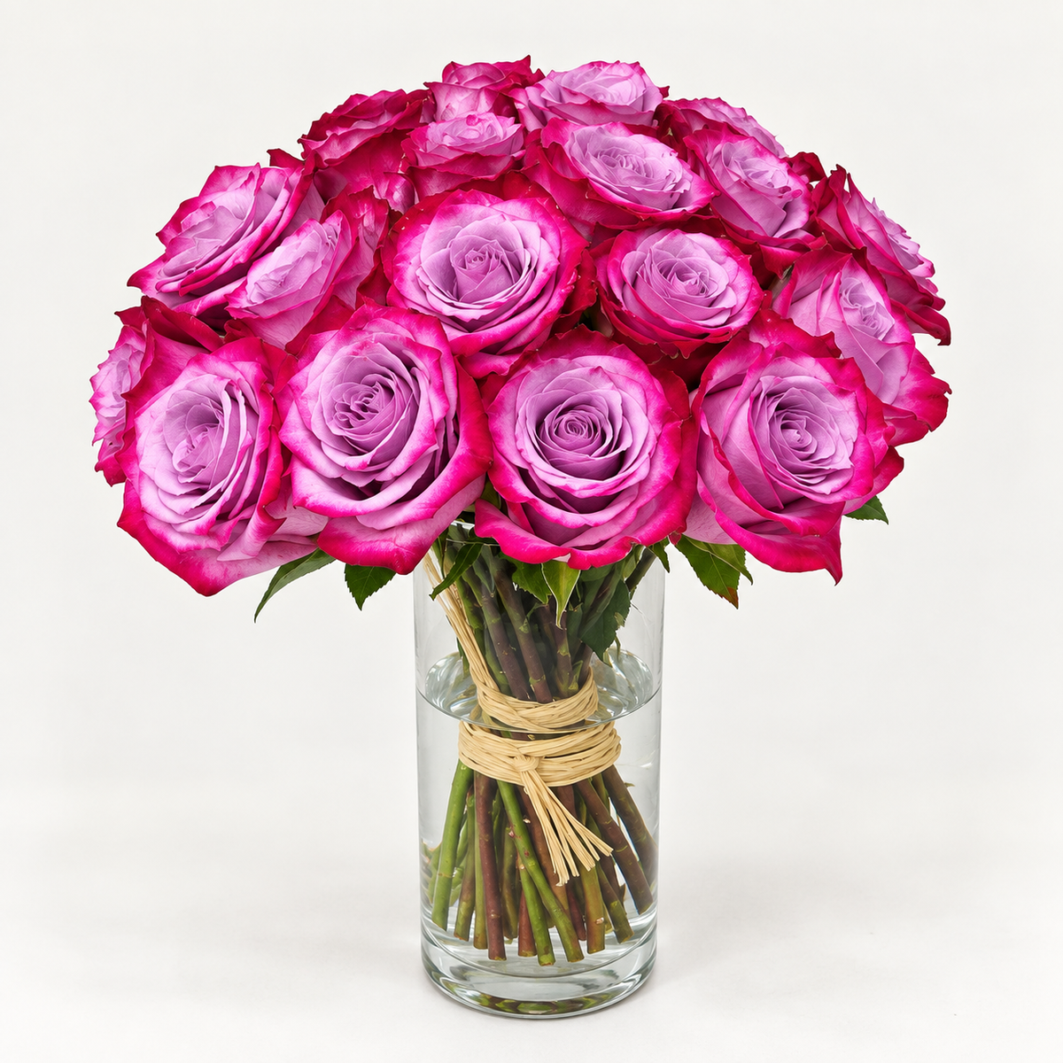 25 fresh purple roses beautifully arranged in a clear glass vase