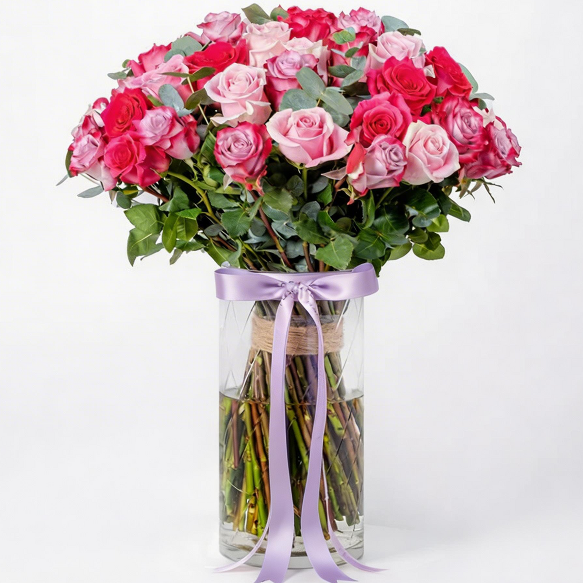 50 mixed red, pink and purple roses beautifully arranged in a glass vase