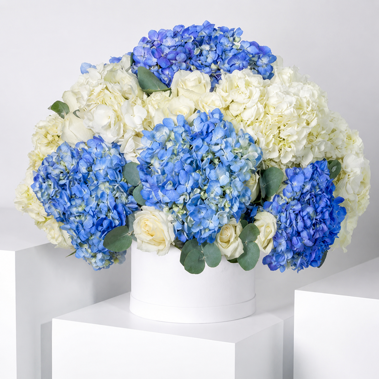 Blue & White Flower Box featuring premium blue hydrangeas, white hydrangeas, white roses and fresh eucalyptus in a luxury flower box.