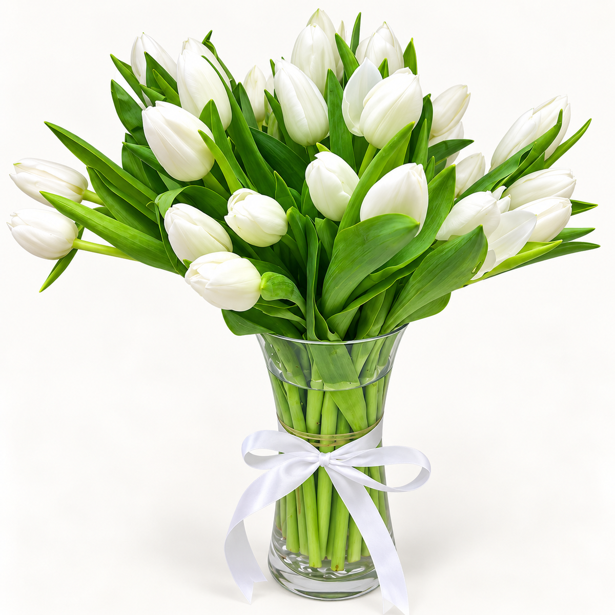 20 fresh white tulips arranged in a clear glass vase