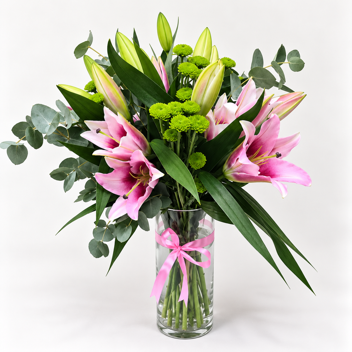 Pink Casablanca lilies vase arrangement featuring six pink lilies, green button flowers, and fresh green leaves arranged beautifully in a vase.